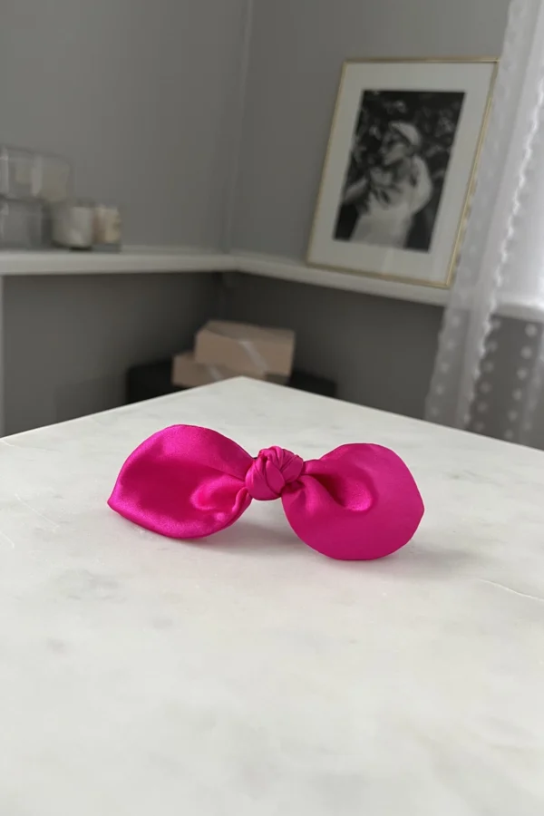 fuchsia silk hair bow on a table